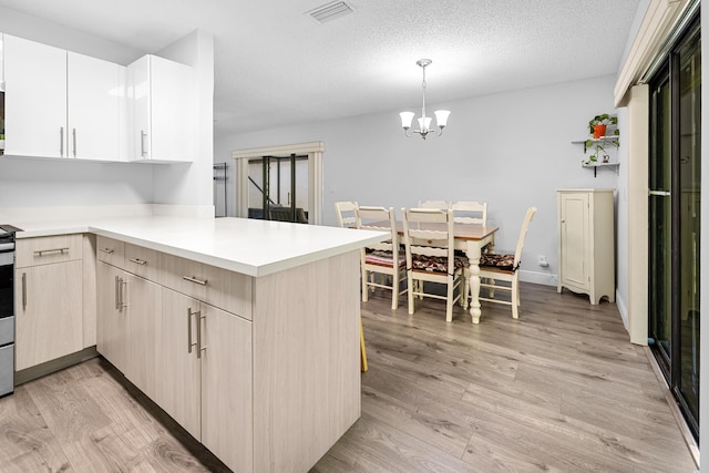 5135 Mirror Lakes Blvd, Boynton Beach, FL 33472 - kitchen featuring a peninsula, light countertops, light wood-style floors, a chandelier, and pendant lighting