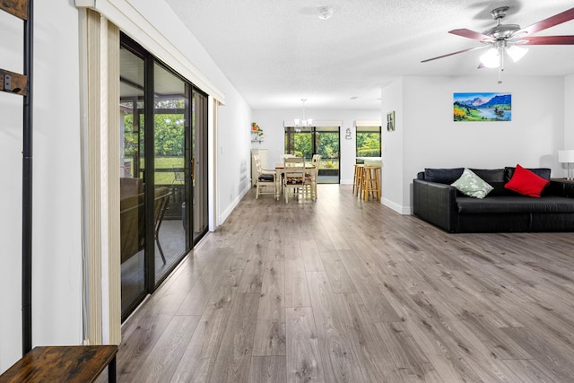 5135 Mirror Lakes Blvd, Boynton Beach, FL 33472 - living area featuring wood finished floors, a chandelier, baseboards, a textured ceiling, and a ceiling fan