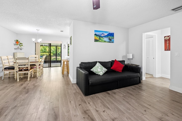 5135 Mirror Lakes Blvd, Boynton Beach, FL 33472 - living area featuring wood finished floors, a textured ceiling, a chandelier, and baseboards