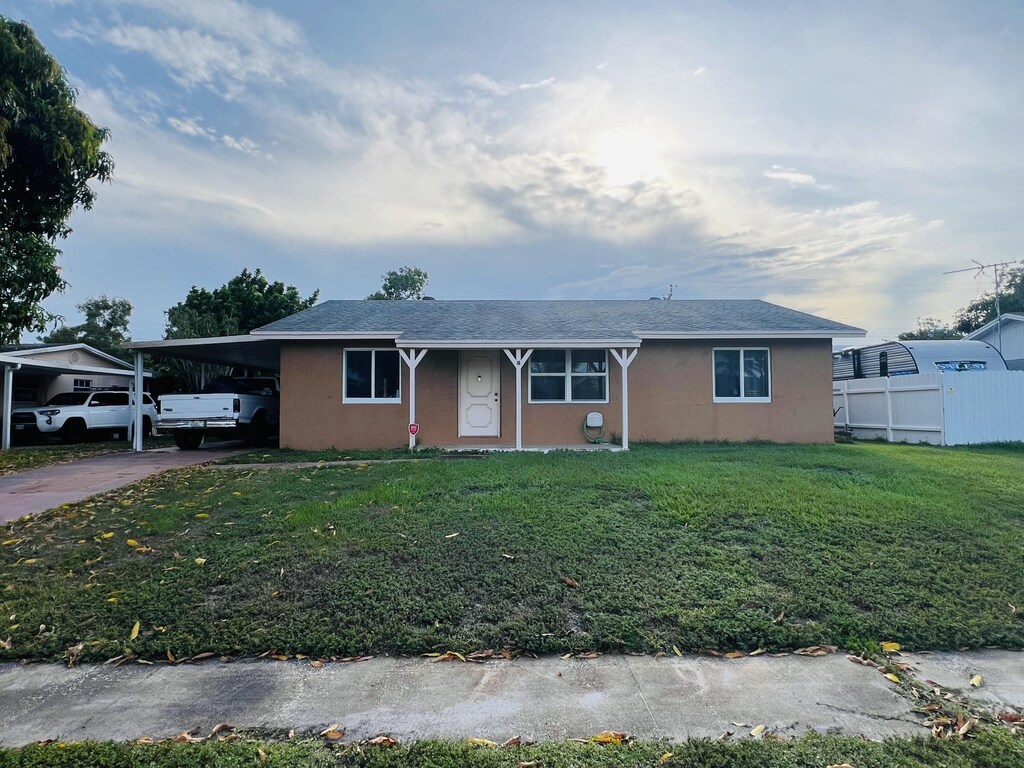 857 Scott Dr, West Palm Beach, FL 33415 - single story home with a carport, driveway, and stucco siding
