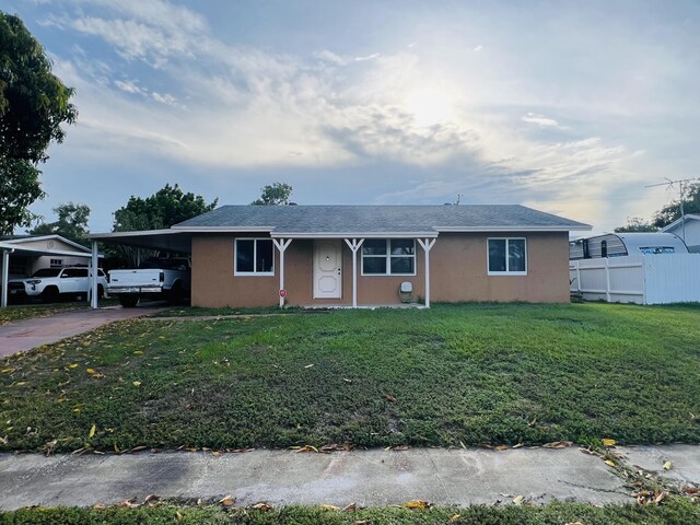 857 Scott Dr, West Palm Beach, FL 33415 - single story home with a carport, driveway, and stucco siding