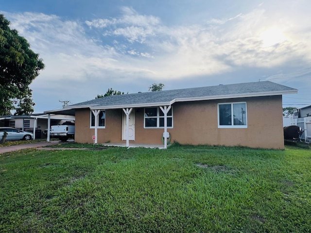 857 Scott Dr, West Palm Beach, FL 33415 - ranch-style house featuring stucco siding, a carport, a front lawn, driveway, and a shingled roof