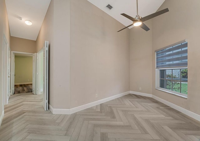 8592 Logia Cir, Boynton Beach, FL 33472 - empty room featuring a towering ceiling, baseboards, and a ceiling fan