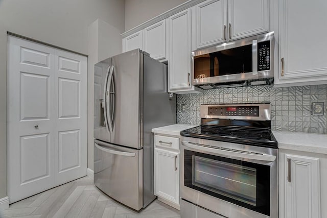 8592 Logia Cir, Boynton Beach, FL 33472 - kitchen featuring stainless steel appliances, tasteful backsplash, white cabinetry, and light stone countertops