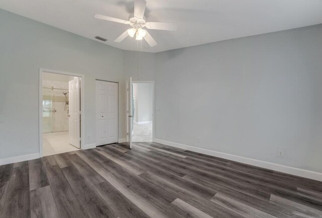 8592 Logia Cir, Boynton Beach, FL 33472 - unfurnished bedroom featuring dark wood-type flooring, connected bathroom, and baseboards