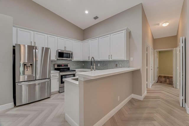 8592 Logia Cir, Boynton Beach, FL 33472 - kitchen featuring appliances with stainless steel finishes, white cabinets, backsplash, light countertops, and baseboards