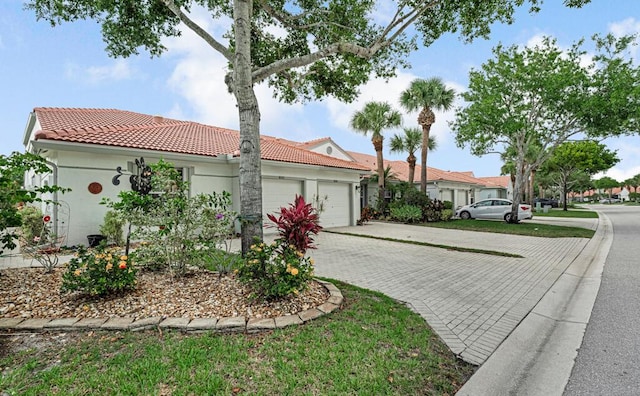 8592 Logia Cir, Boynton Beach, FL 33472 - view of front of property featuring an attached garage, decorative driveway, a tiled roof, and stucco siding
