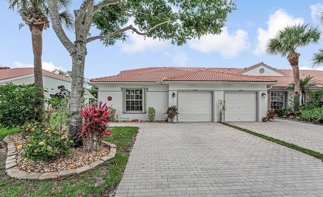 8592 Logia Cir, Boynton Beach, FL 33472 - mediterranean / spanish-style house with a garage, a tile roof, decorative driveway, and stucco siding