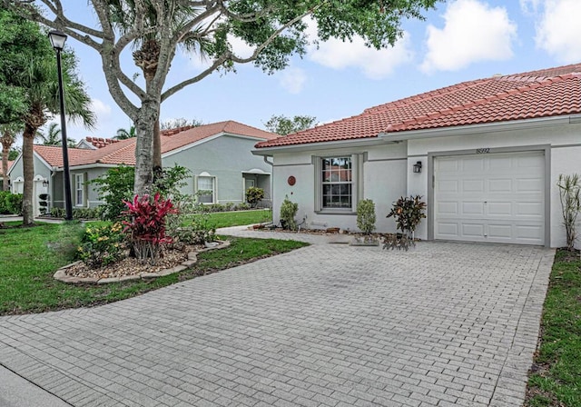 8592 Logia Cir, Boynton Beach, FL 33472 - mediterranean / spanish home featuring a tiled roof, an attached garage, stucco siding, driveway, and a front yard