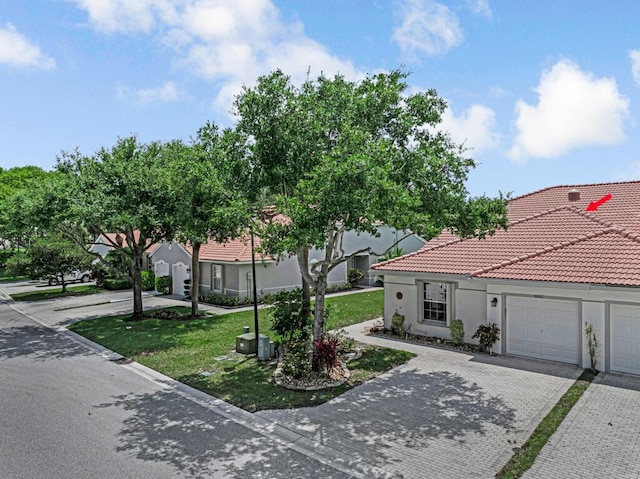 8592 Logia Cir, Boynton Beach, FL 33472 - view of front of house featuring decorative driveway, stucco siding, a tile roof, a front yard, and a garage