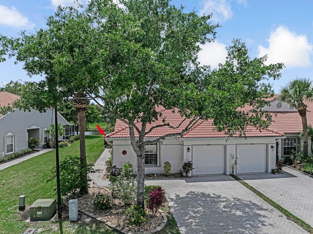 8592 Logia Cir, Boynton Beach, FL 33472 - view of front of property with an attached garage, decorative driveway, stucco siding, and a front lawn