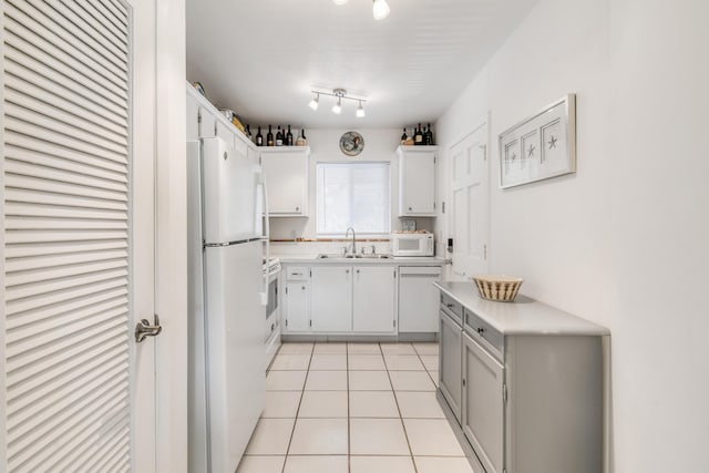 4 Garden St Unit 204N, Tequesta, FL 33469 - kitchen featuring white appliances, light countertops, a sink, light tile patterned flooring, and white cabinets