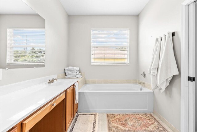 2481 SE Berkshire Blvd, Port Saint Lucie, FL 34952 - bathroom featuring a garden tub, tile patterned floors, and vanity