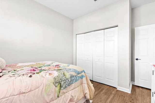 2481 SE Berkshire Blvd, Port Saint Lucie, FL 34952 - bedroom with wood finished floors, a closet, and baseboards