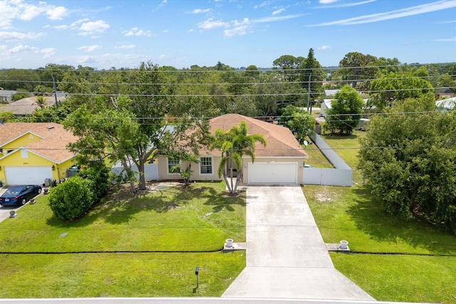 2481 SE Berkshire Blvd, Port Saint Lucie, FL 34952 - view of front facade featuring driveway, an attached garage, a front yard, and stucco siding