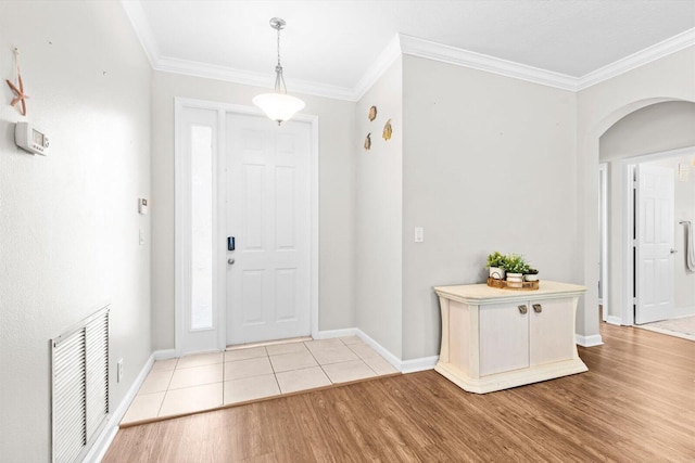 2481 SE Berkshire Blvd, Port Saint Lucie, FL 34952 - entryway featuring arched walkways, light wood-type flooring, crown molding, and baseboards