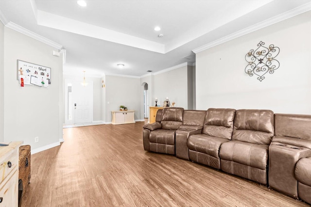2481 SE Berkshire Blvd, Port Saint Lucie, FL 34952 - living room featuring arched walkways, light wood finished floors, a raised ceiling, recessed lighting, and crown molding
