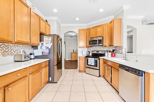 2481 SE Berkshire Blvd, Port Saint Lucie, FL 34952 - kitchen featuring stainless steel appliances, arched walkways, crown molding, a sink, and light tile patterned flooring