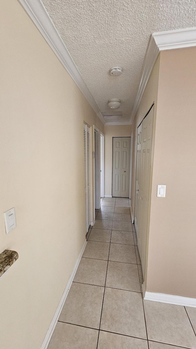 11474 NW 42nd St Unit 11474, Coral Springs, FL 33065 - hall featuring crown molding, light tile patterned flooring, a textured ceiling, and baseboards