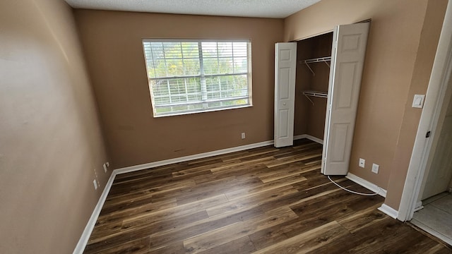 11474 NW 42nd St Unit 11474, Coral Springs, FL 33065 - unfurnished bedroom featuring dark wood-type flooring, baseboards, and a closet