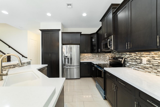 3040 Princeton Ln, Palm Beach Gardens, FL 33418 - kitchen featuring appliances with stainless steel finishes, a sink, light countertops, tasteful backsplash, and recessed lighting