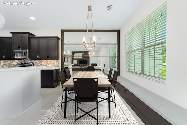 3040 Princeton Ln, Palm Beach Gardens, FL 33418 - dining room featuring light tile patterned floors and a chandelier