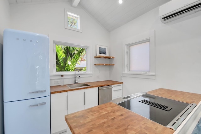 220 S L St, Lake Worth Beach, FL 33460 - kitchen with freestanding refrigerator, wood counters, a sink, an AC wall unit, and dishwasher