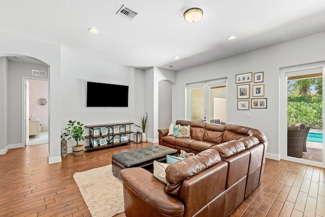 8940 New Hope Ct, West Palm Beach, FL 33411 - living area with arched walkways, wood finished floors, a textured ceiling, recessed lighting, and baseboards