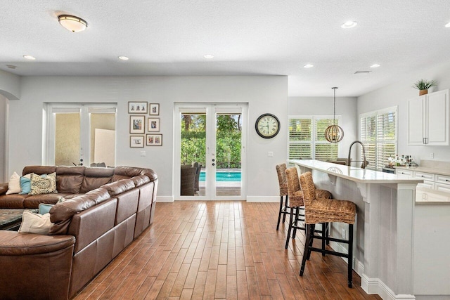 8940 New Hope Ct, West Palm Beach, FL 33411 - living area featuring wood finished floors, recessed lighting, baseboards, arched walkways, and a textured ceiling