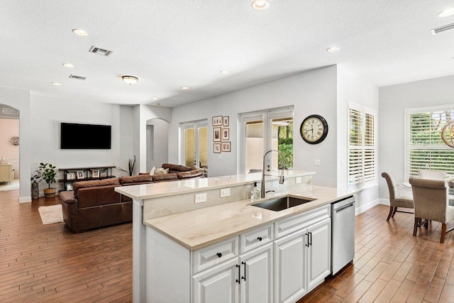 8940 New Hope Ct, West Palm Beach, FL 33411 - kitchen featuring a sink, arched walkways, dishwasher, dark wood-type flooring, and white cabinetry