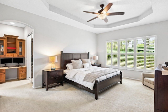 8940 New Hope Ct, West Palm Beach, FL 33411 - bedroom featuring light colored carpet, arched walkways, baseboards, a desk, and a tray ceiling