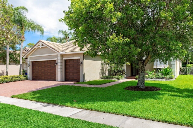 8940 New Hope Ct, West Palm Beach, FL 33411 - view of front of property featuring decorative driveway, a garage, a front yard, stucco siding, and a tile roof