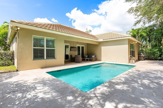 8940 New Hope Ct, West Palm Beach, FL 33411 - rear view of property featuring a patio area, outdoor lounge area, an outdoor pool, and stucco siding
