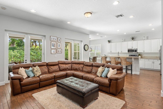 8940 New Hope Ct, West Palm Beach, FL 33411 - living room featuring wood-type flooring, recessed lighting, and a textured ceiling