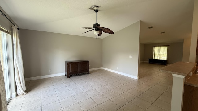 2134 SW Savage Blvd, Port Saint Lucie, FL 34953 - empty room featuring lofted ceiling, light tile patterned floors, ceiling fan, and baseboards