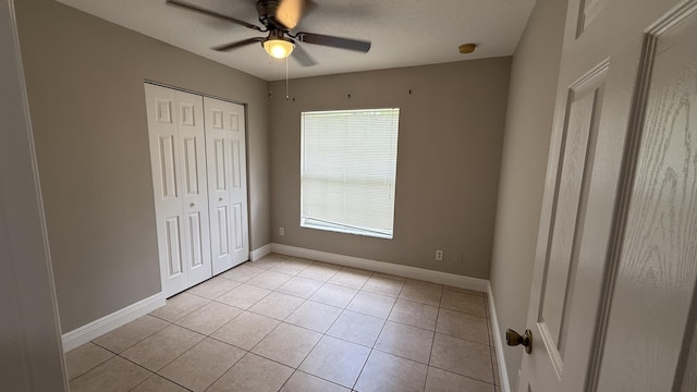 2134 SW Savage Blvd, Port Saint Lucie, FL 34953 - unfurnished bedroom with a closet, baseboards, light tile patterned floors, and a ceiling fan