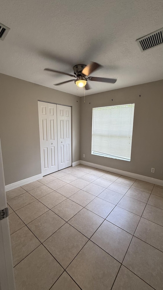 2134 SW Savage Blvd, Port Saint Lucie, FL 34953 - unfurnished bedroom with a closet, light tile patterned flooring, a textured ceiling, and baseboards
