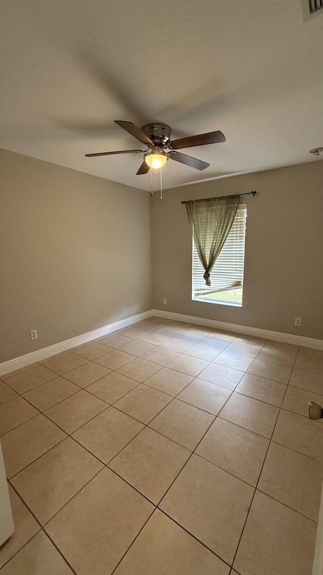2134 SW Savage Blvd, Port Saint Lucie, FL 34953 - spare room with light tile patterned flooring, a ceiling fan, and baseboards