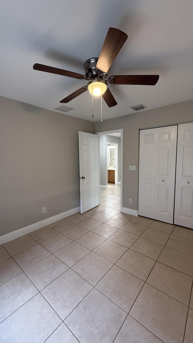 2134 SW Savage Blvd, Port Saint Lucie, FL 34953 - unfurnished bedroom featuring light tile patterned floors, a closet, baseboards, and a ceiling fan