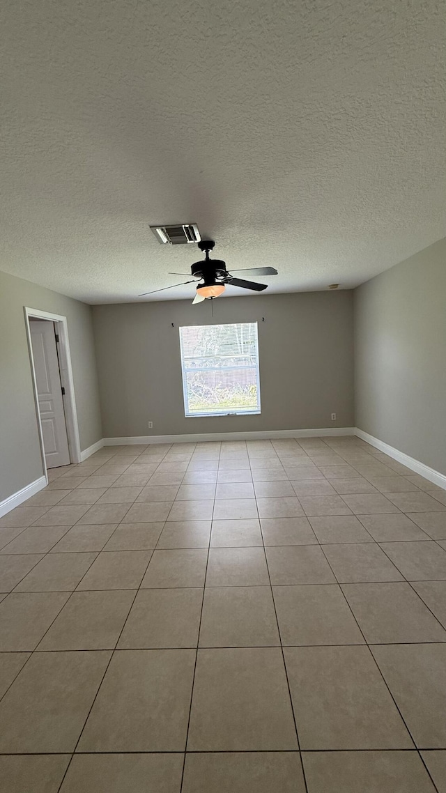 2134 SW Savage Blvd, Port Saint Lucie, FL 34953 - empty room featuring a ceiling fan, light tile patterned flooring, a textured ceiling, and baseboards