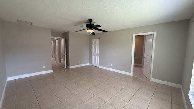 2134 SW Savage Blvd, Port Saint Lucie, FL 34953 - empty room with a ceiling fan, light tile patterned flooring, a textured ceiling, and baseboards