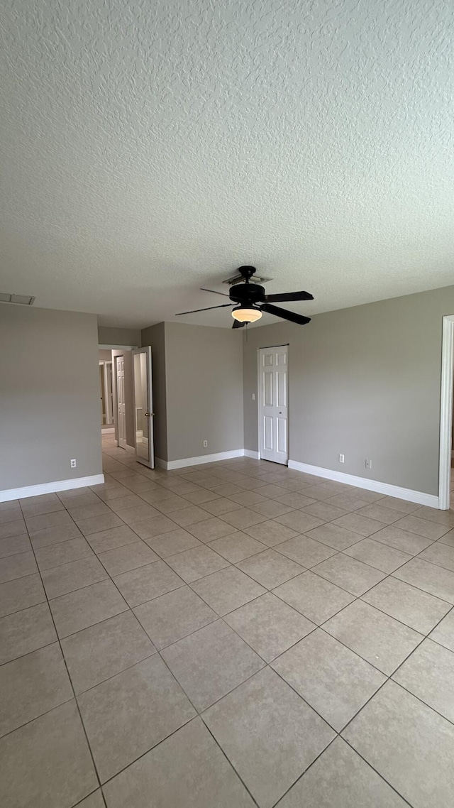 2134 SW Savage Blvd, Port Saint Lucie, FL 34953 - unfurnished room featuring baseboards, a textured ceiling, ceiling fan, and light tile patterned floors