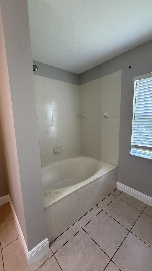 2134 SW Savage Blvd, Port Saint Lucie, FL 34953 - bathroom with a bathtub, tile patterned floors, a textured ceiling, and baseboards