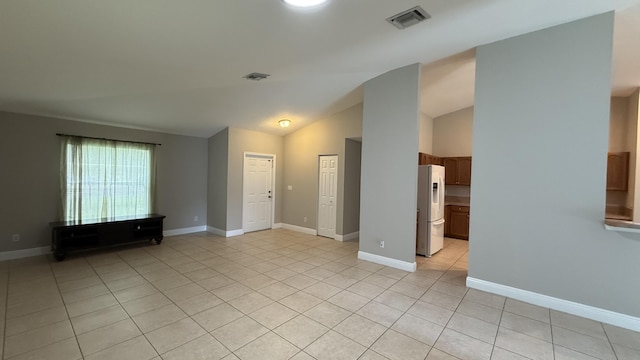 2134 SW Savage Blvd, Port Saint Lucie, FL 34953 - unfurnished living room featuring light tile patterned flooring, baseboards, and vaulted ceiling