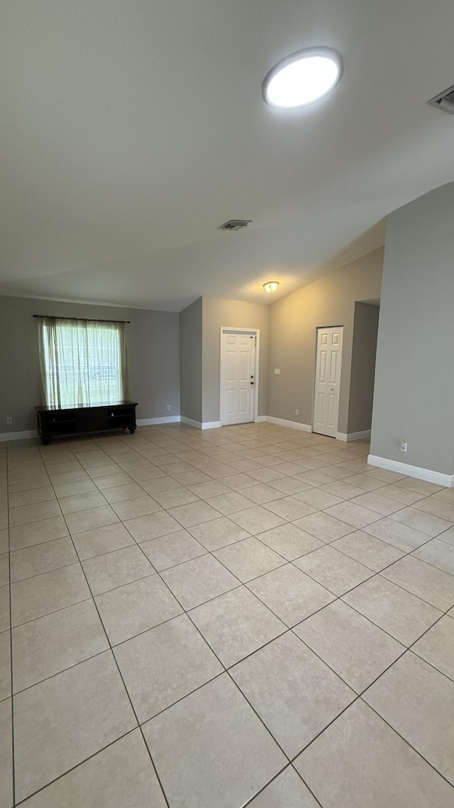 2134 SW Savage Blvd, Port Saint Lucie, FL 34953 - empty room with light tile patterned floors, baseboards, and lofted ceiling