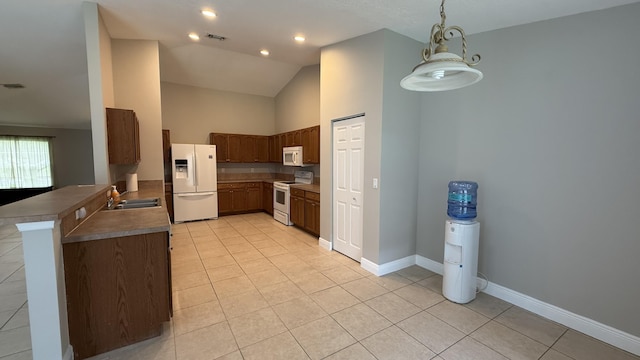 2134 SW Savage Blvd, Port Saint Lucie, FL 34953 - kitchen featuring white appliances, light tile patterned floors, a sink, a peninsula, and baseboards