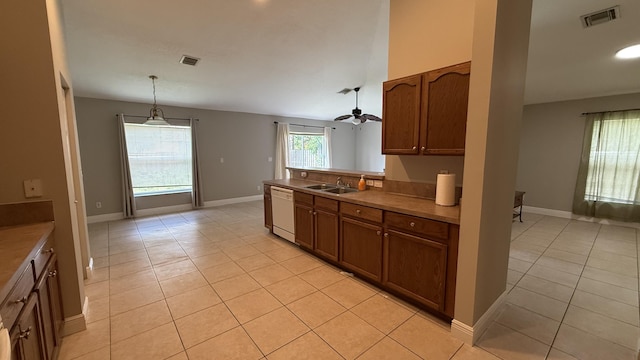 2134 SW Savage Blvd, Port Saint Lucie, FL 34953 - kitchen with white dishwasher, a sink, light tile patterned floors, and brown cabinets