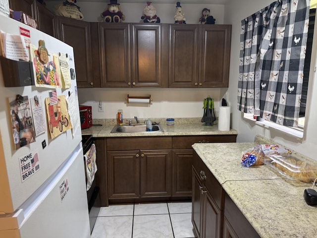 37 Waltham Unit B, West Palm Beach, FL 33417 - kitchen with freestanding refrigerator, a sink, light countertops, and light tile patterned floors