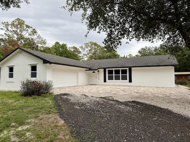 2812 F Rd, Loxahatchee Groves, FL 33470 - view of front of home featuring a garage, driveway, stucco siding, and roof with shingles