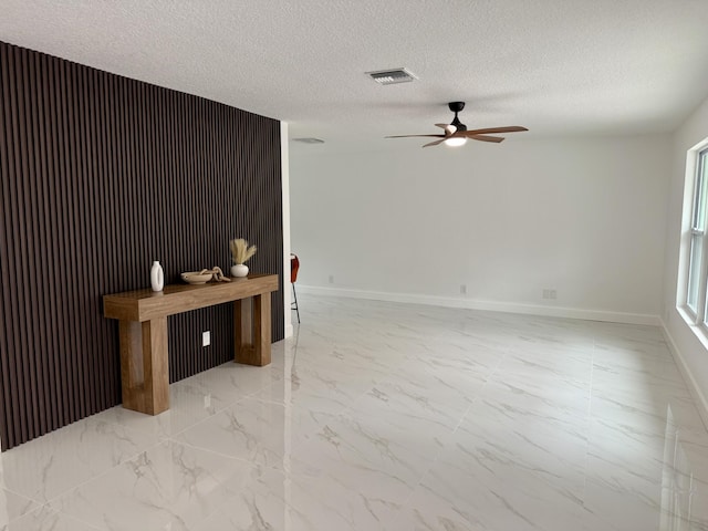 2812 F Rd, Loxahatchee Groves, FL 33470 - spare room featuring light marble finish floors, ceiling fan, a textured ceiling, and baseboards